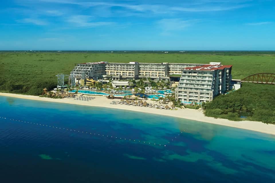 All-inclusive beachfront resort with multiple building towers and bright blue pool areas