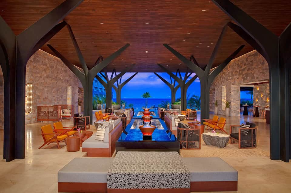 Luxurious beachfront lounge with fireplace, ocean views, and modern architectural design