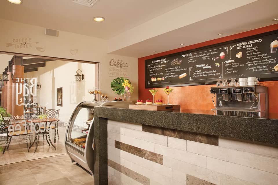 Modern coffee shop interior with orange accent wall, menu board, and service counter