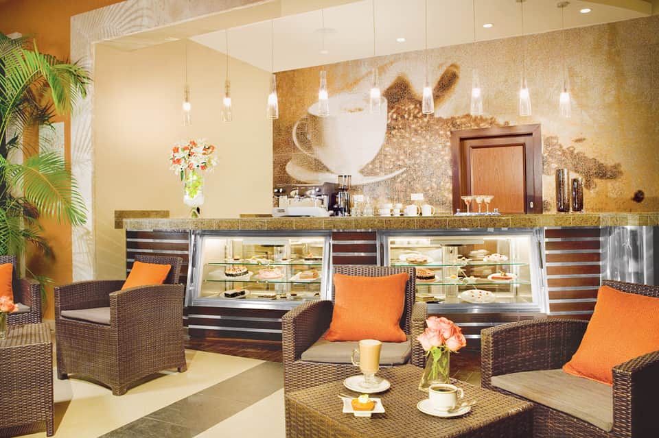 Modern spa reception with gold accent wall, pendant lights, and wicker seating