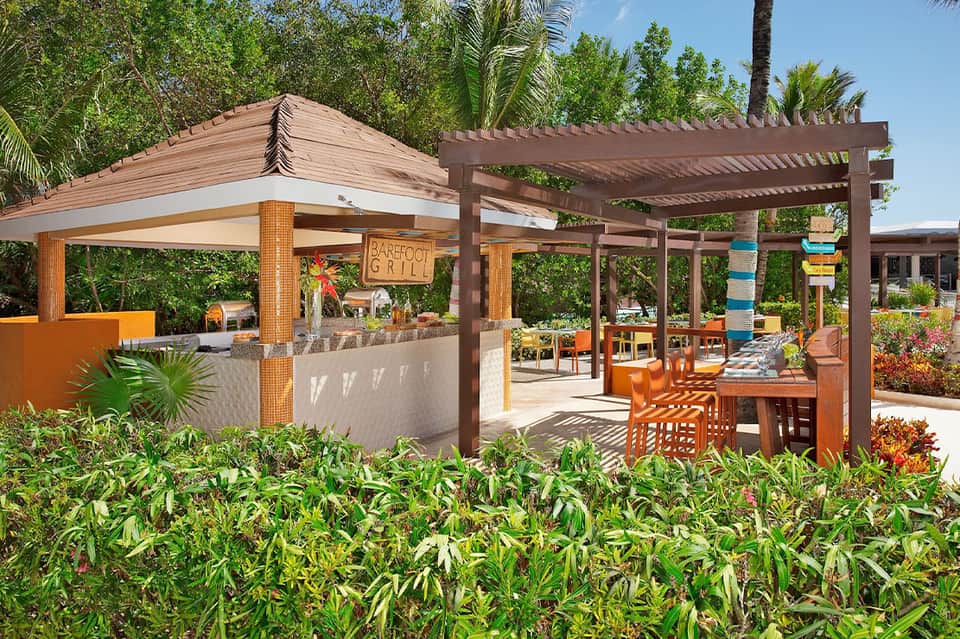 Barefoot Grill restaurant with wooden pergola, orange accents, and tropical landscaping