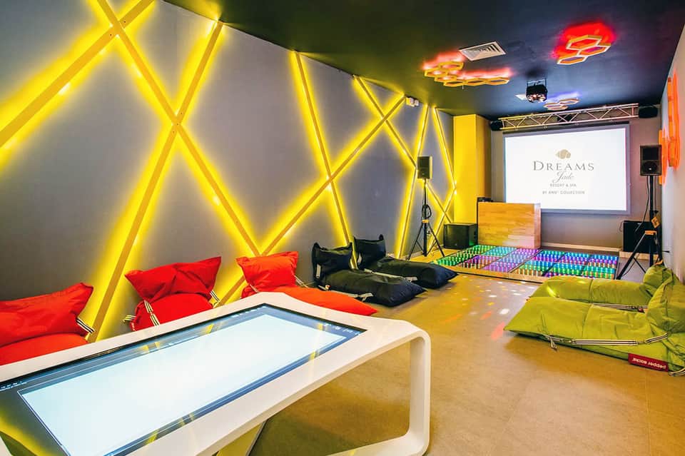 Contemporary lounge space with bright yellow neon geometric wall art and colorful seating
