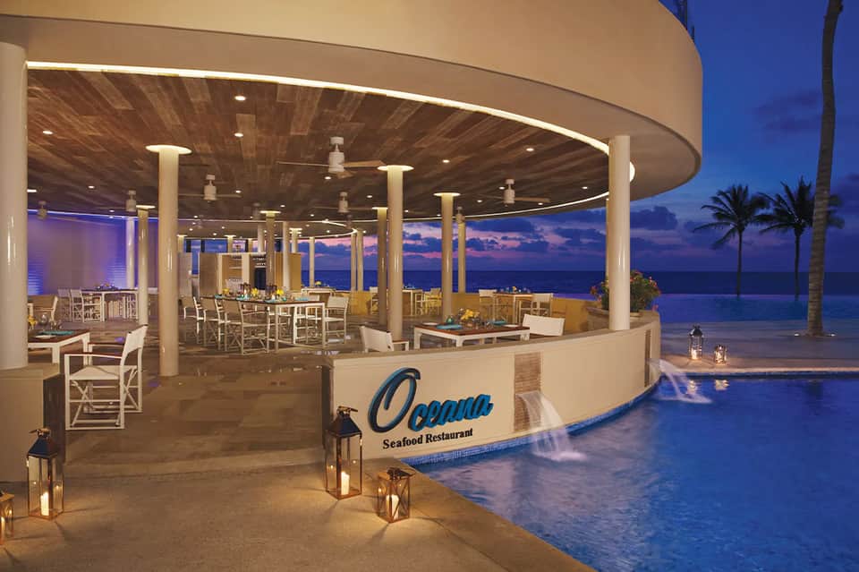 Elegant Oceana seafood restaurant at dusk overlooking the ocean with circular wooden ceiling and columns