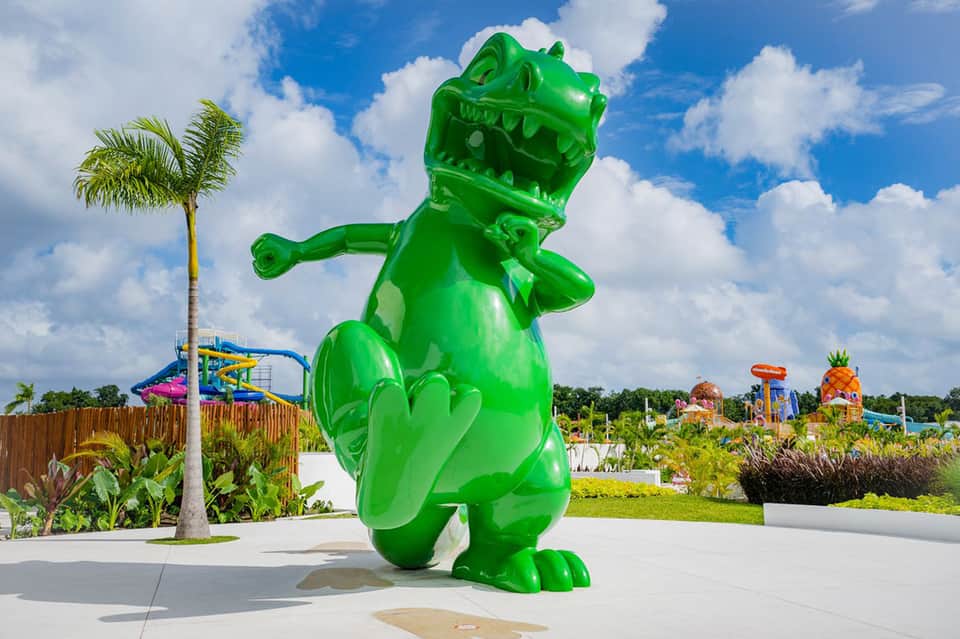 Large green dinosaur sculpture at an outdoor family entertainment park