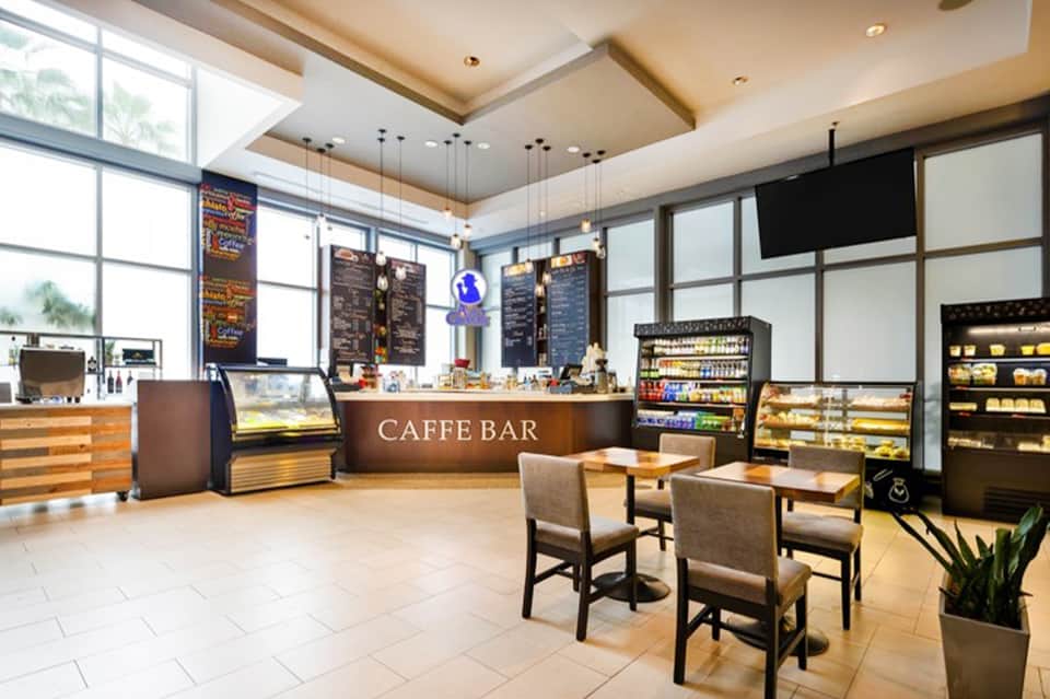 Modern hotel café bar with exposed brick, pendant lighting, and display cases
