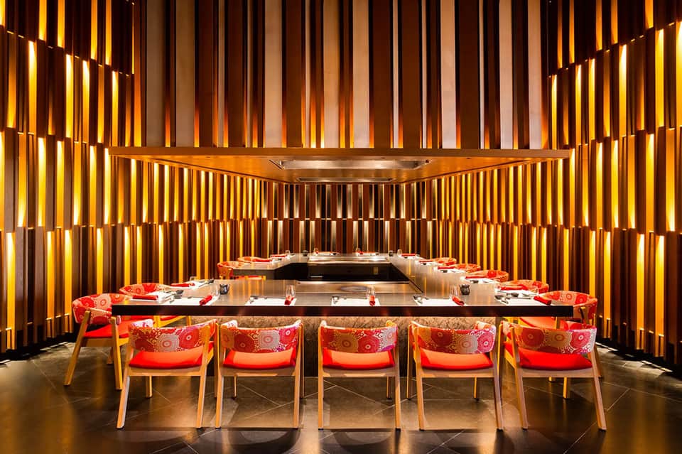 Modern private dining room with gold-paneled walls and chef's table setup