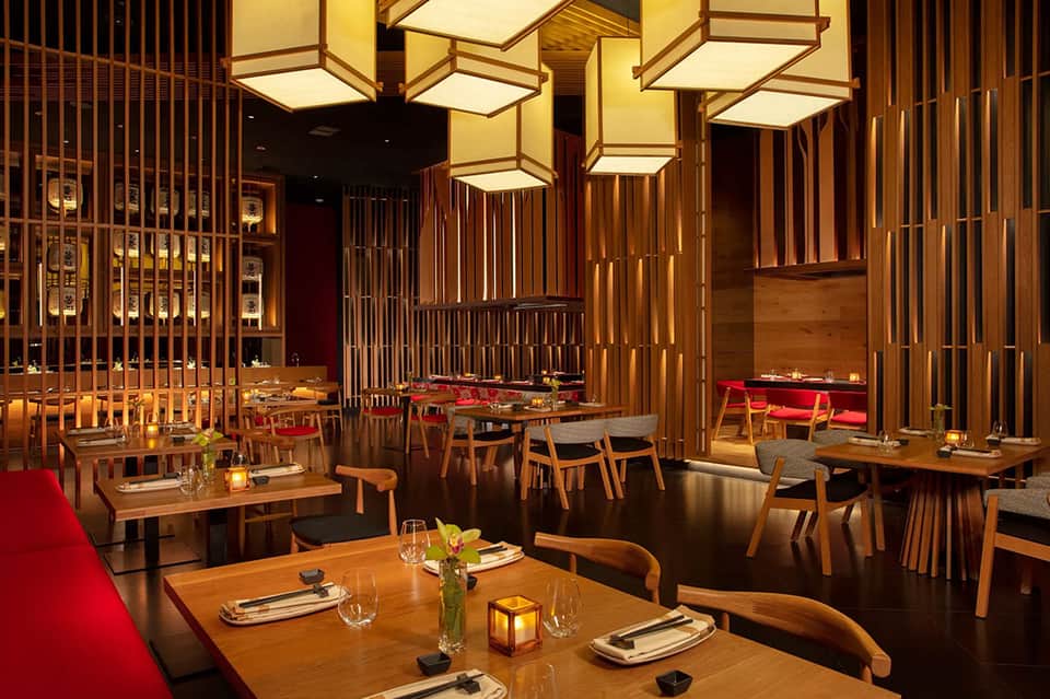 Upscale restaurant interior with wooden partitions, warm lighting, and red accents