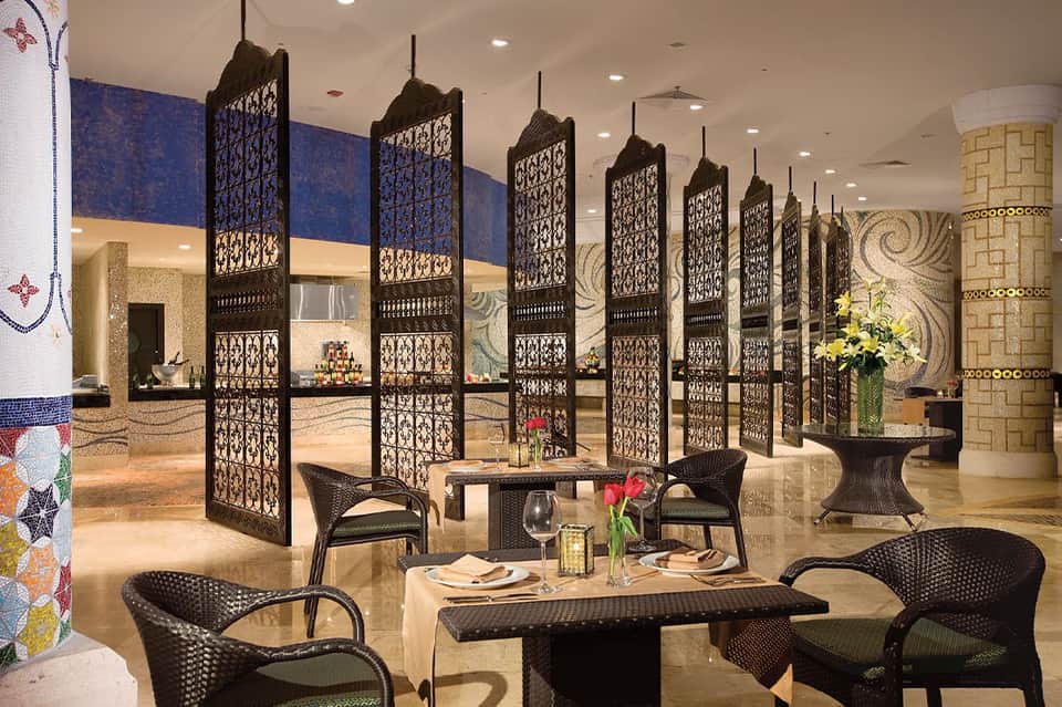 Elegant indoor dining space with decorative black lattice panels and black wicker chairs