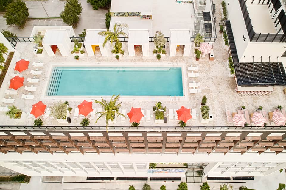 Overhead view of rectangular pool surrounded by colorful umbrellas and loungers