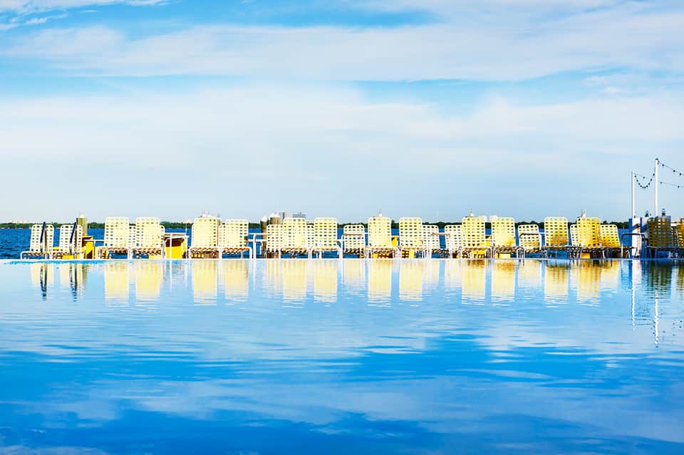 Yellow beachfront buildings reflected in calm blue water