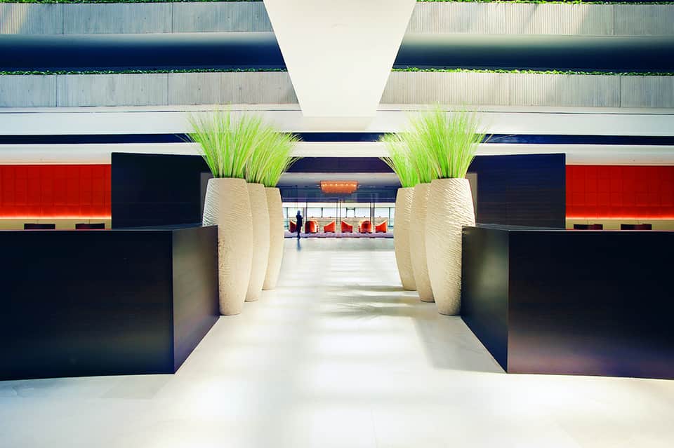 Contemporary hotel entrance hallway with geometric design and potted plants