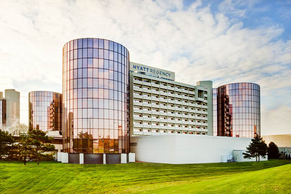 Hyatt Regency hotel with distinctive cylindrical glass towers and manicured lawn
