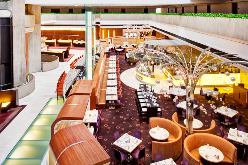 Upscale dining room interior with dramatic copper sculptures, wood paneling, and multiple seating areas