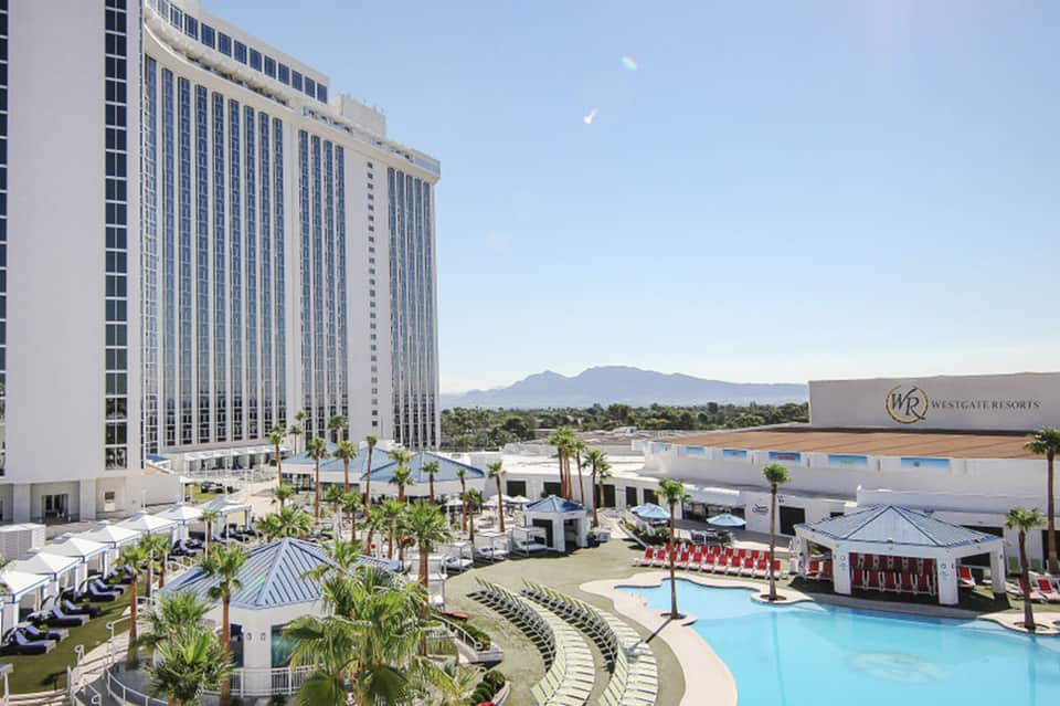Westgate Resorts high-rise hotel tower with resort pool, palm trees, and desert mountain backdrop