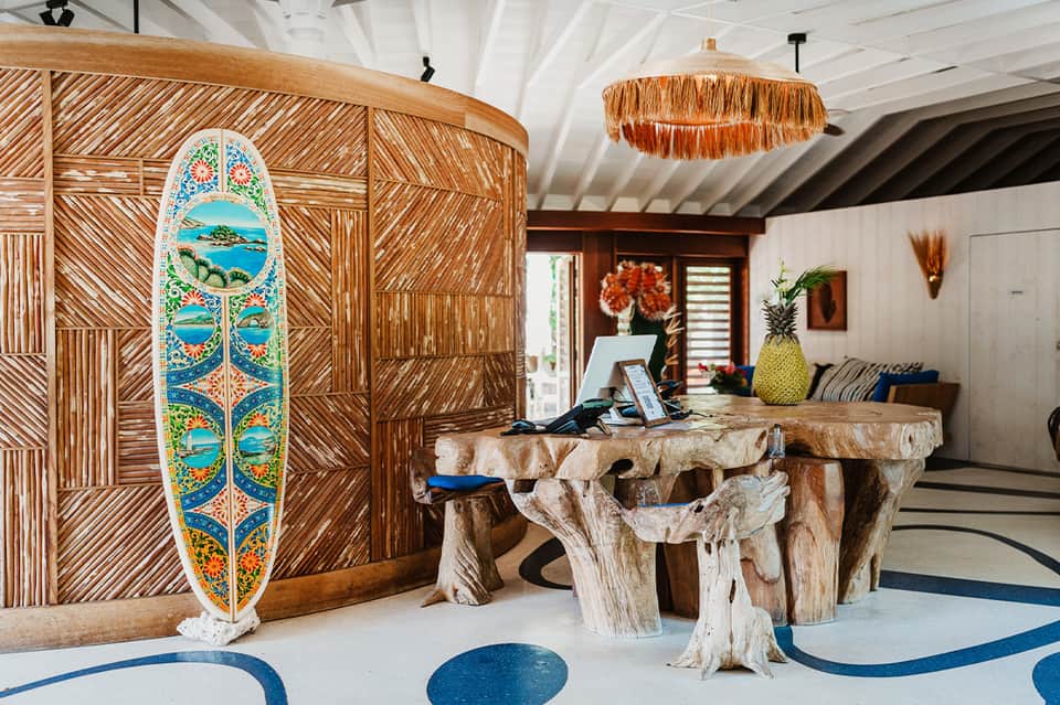 Tropical resort lobby with surfboard decor and wooden furnishings