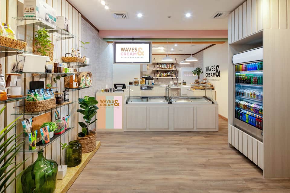 Modern gelato and coffee shop interior with white cabinetry and retail display