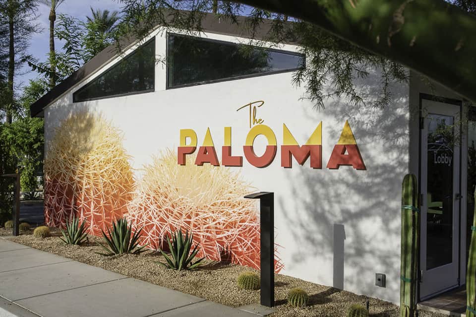 The Paloma resort entrance with desert landscaping, cactus graphics, and modern white architecture