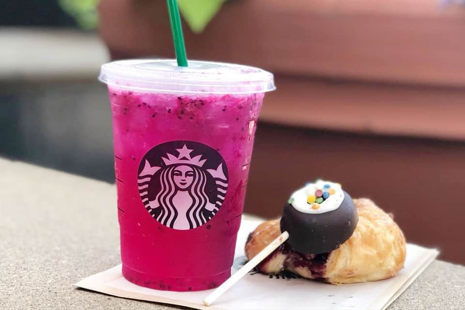 Pink Starbucks beverage and pastry on outdoor patio surface