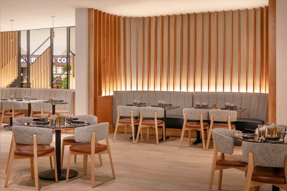 Contemporary restaurant interior with wooden slat walls, modern furniture, and warm ambient lighting