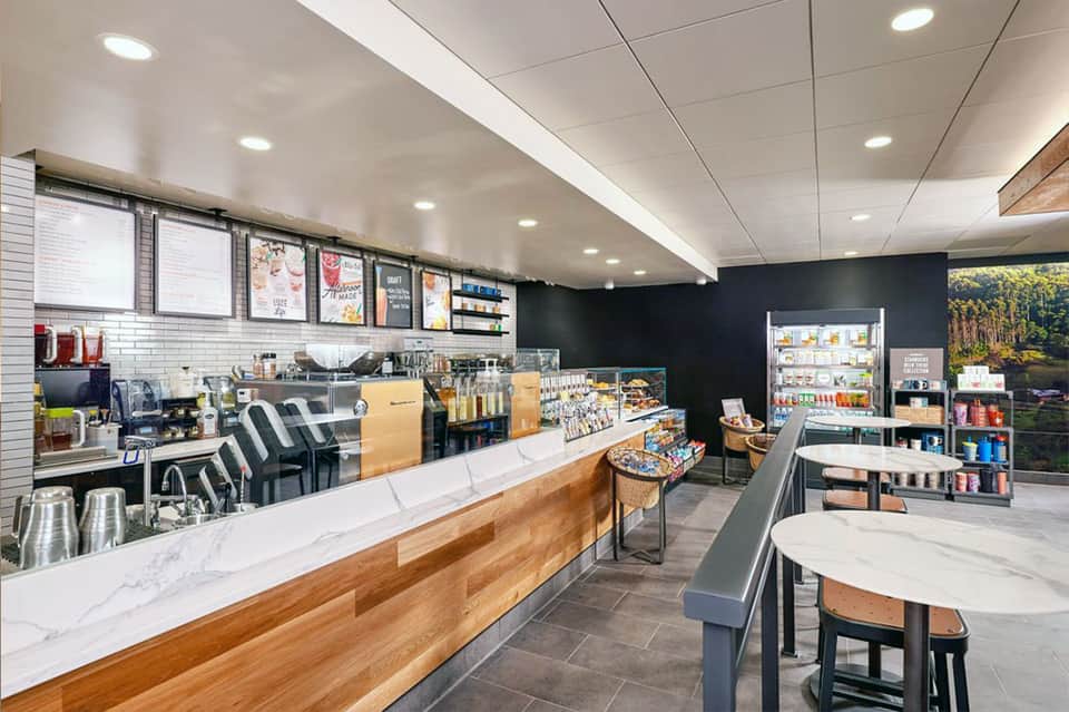 Modern coffee shop counter with menu boards and beverage stations