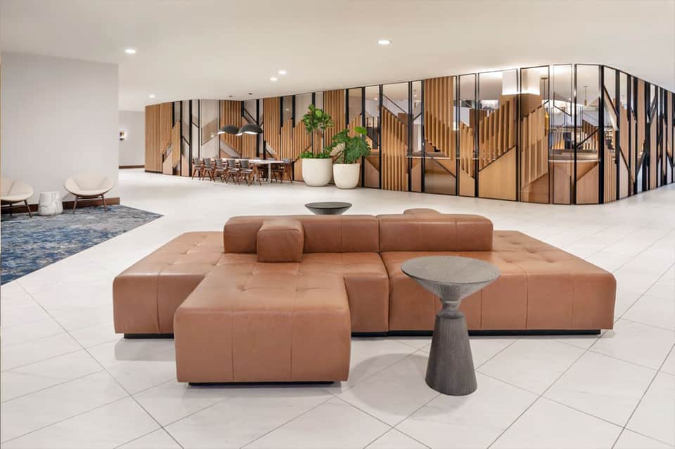 Modern hotel lobby with brown leather seating and wood partition walls