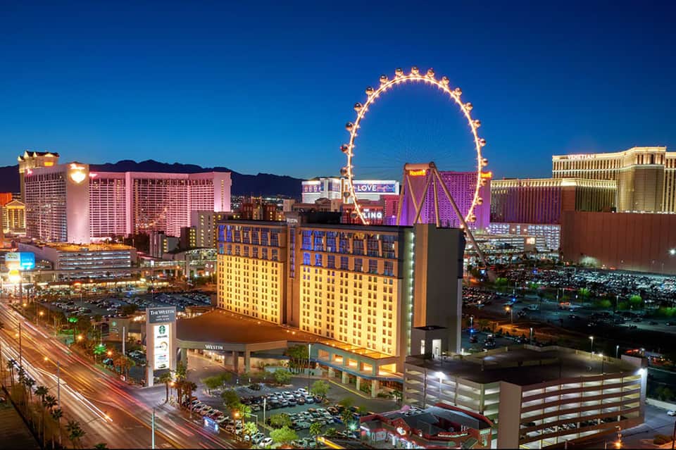 Las Vegas Strip skyline at night featuring illuminated Ferris wheel and colorful hotel lights