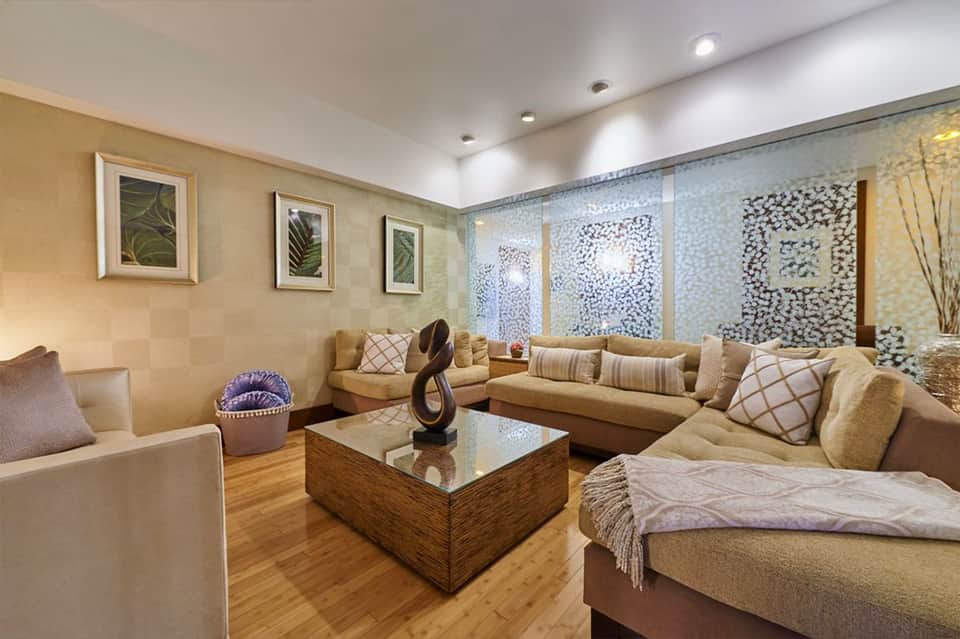 Elegant living room with beige sofas, fireplace, wood table, and decorative wall art