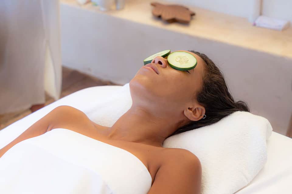 Woman relaxing with cucumber facial mask during spa treatment