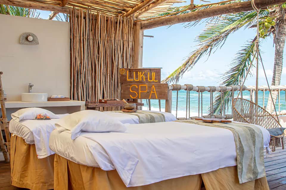 Beachfront spa treatment room with ocean view and palm trees