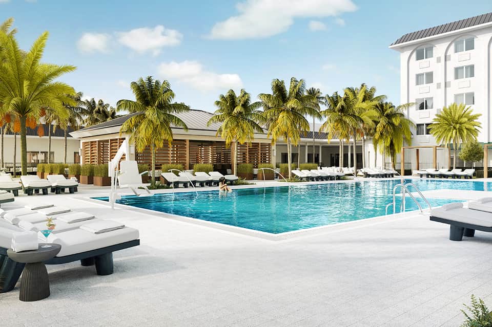 Tropical resort pool with palm trees, white lounge chairs, and modern architecture