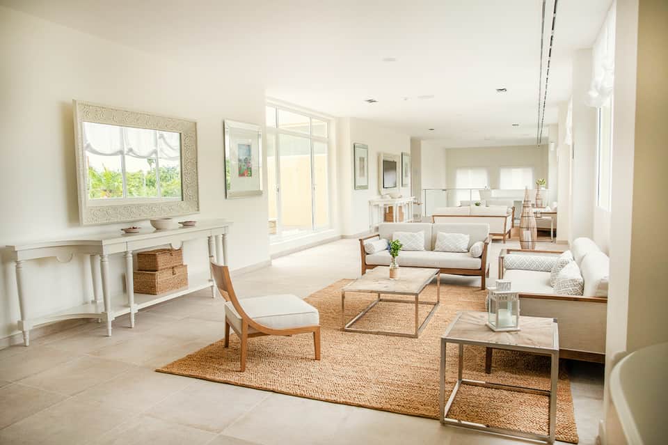 Elegant bright lounge with neutral furnishings, natural light, and coastal modern décor