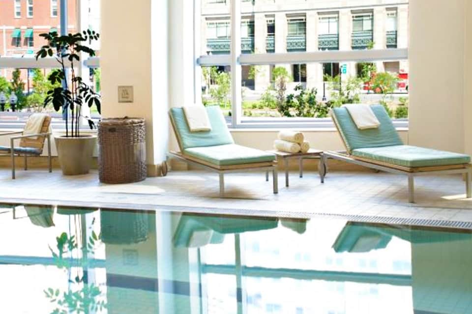 Spa relaxation area with lounge chairs, plants, and ocean view through large windows