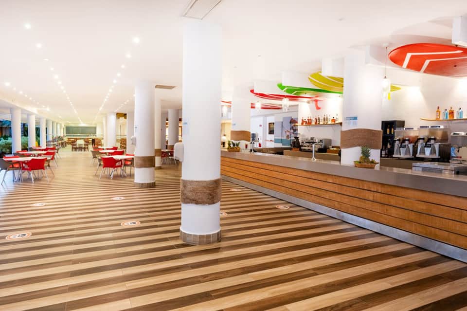 Modern hotel lobby with reception desk, dining area, and contemporary décor with colorful artwork