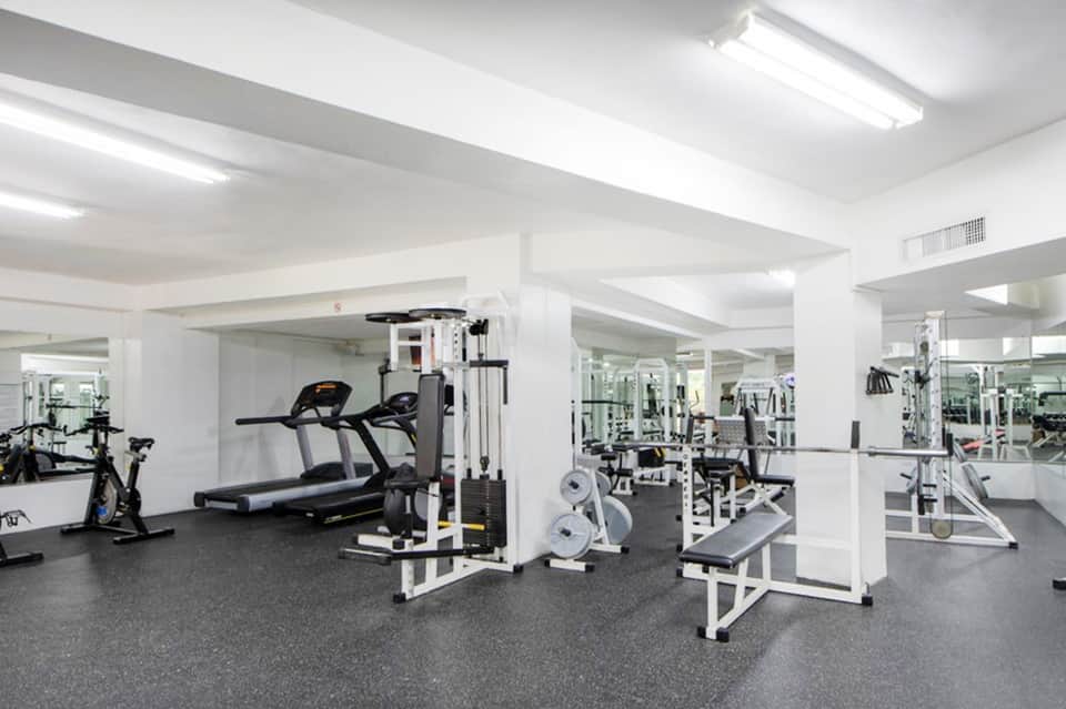 Modern fitness center with treadmills, weight machines, and mirrored walls