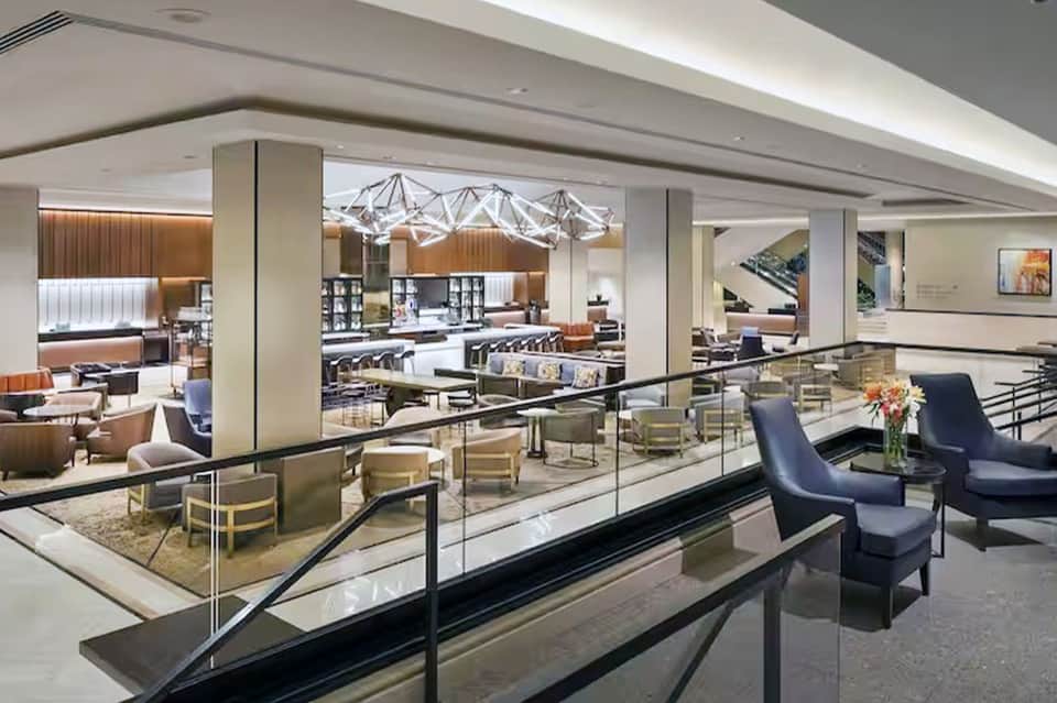Modern hotel interior mezzanine level with contemporary furniture and glass railings