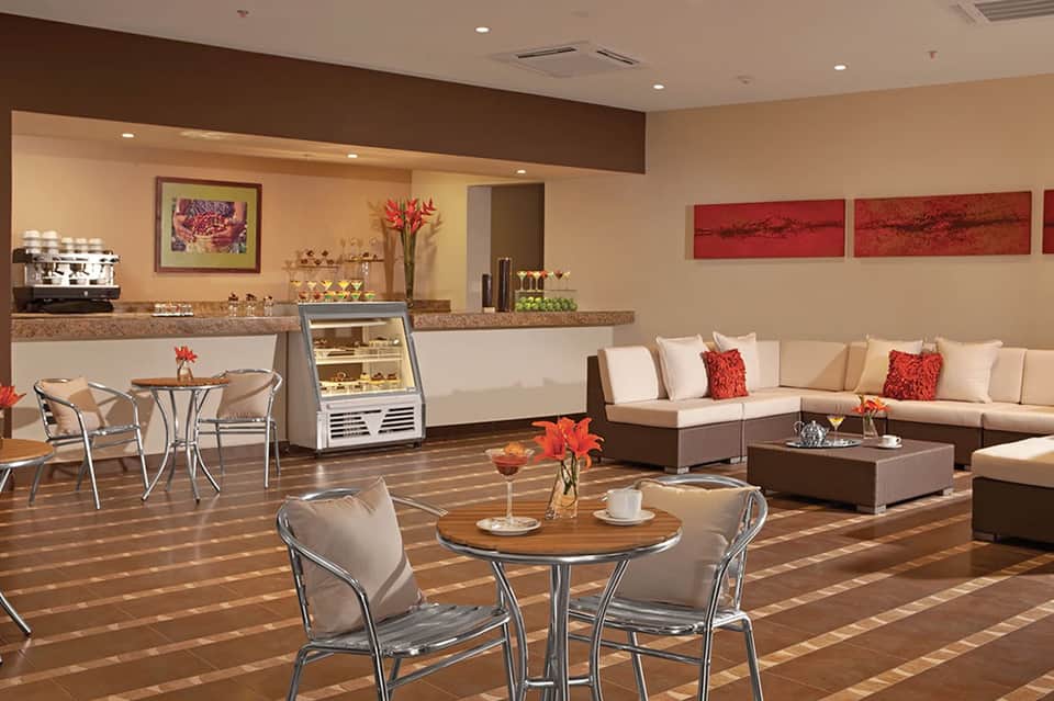 Upscale spa lounge with cream and brown tones, comfortable seating, counter service, and floral décor