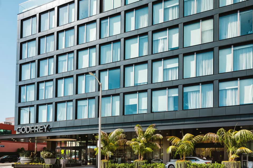 Modern hotel building exterior with geometric window pattern and dark metal framing