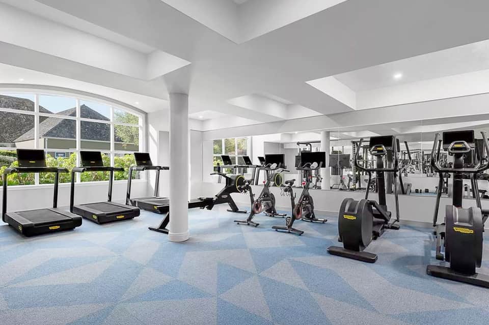 State-of-the-art fitness center with treadmills, exercise bikes, and gym equipment under natural light