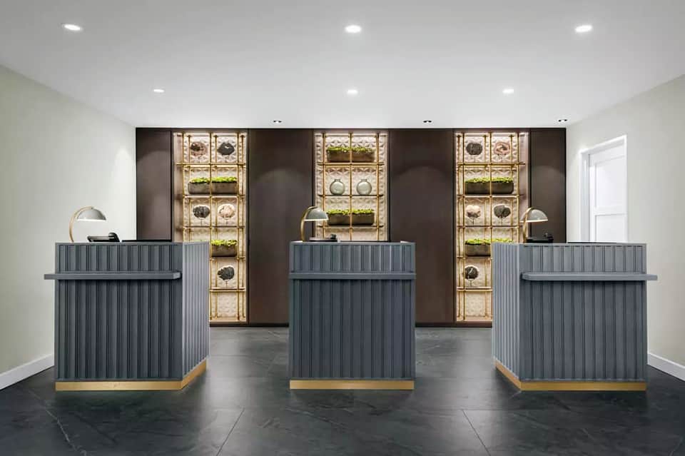 Luxury hotel lobby with three reception desks and decorative plant wall installations
