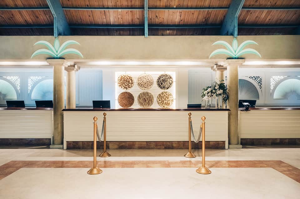 Resort check-in desk with palm decorations and modern coastal design