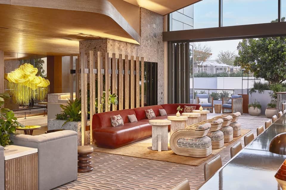 Luxury lounge with red sofa, modern furnishings, and waterfront views through glass walls