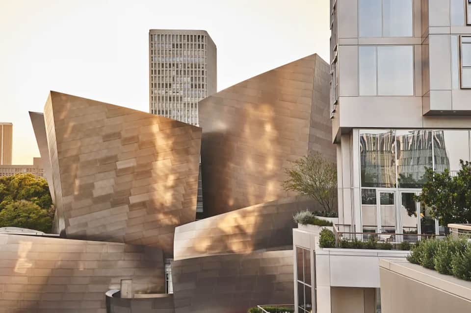 Modern architectural building exterior with tilted copper-colored metal walls and contemporary glass facade