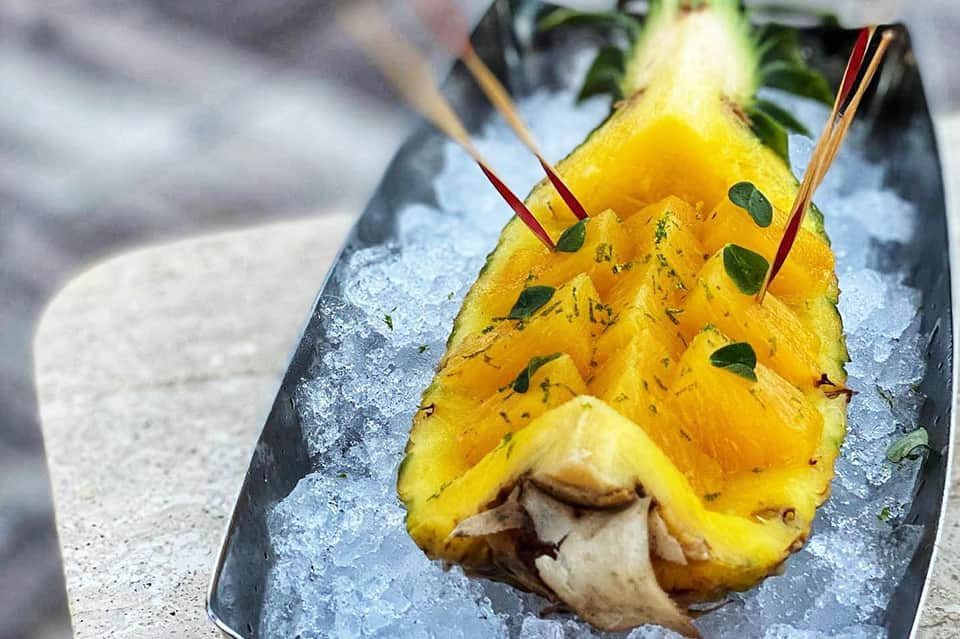 Artfully plated tropical cocktail with fresh pineapple and mint garnish on ice