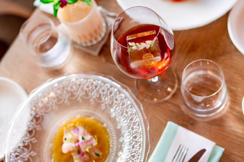 Fine dining table setting with plated dish, wine glass, and decorative place setting