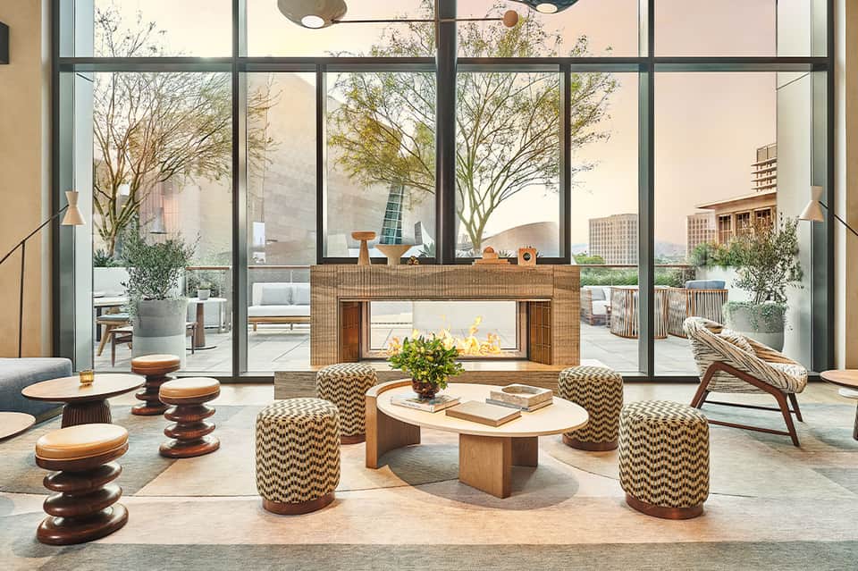 Modern living room with fireplace, floor-to-ceiling windows, and city skyline views
