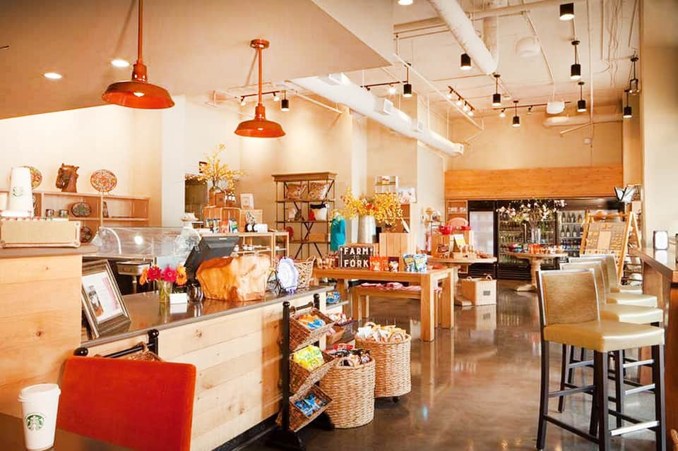 Warm-toned casual café with wooden counters, hanging copper lights, and farm decor