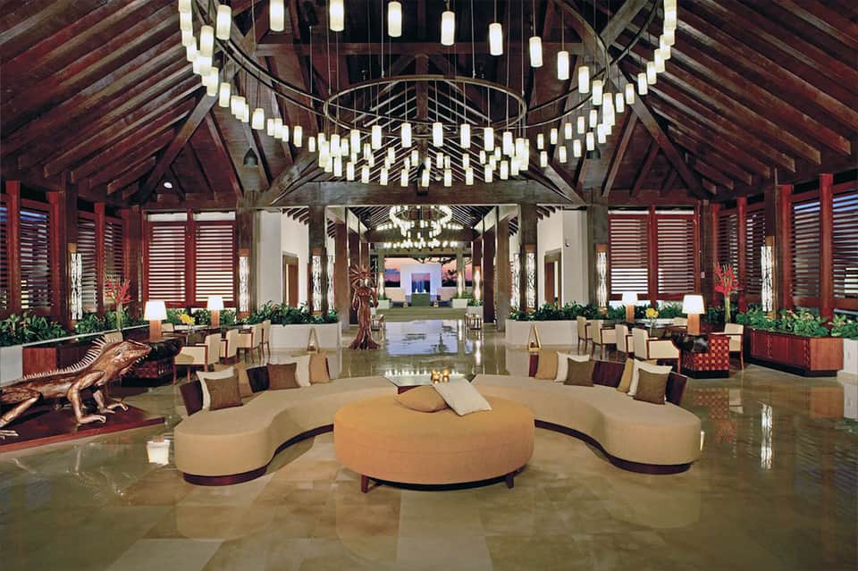Luxurious resort lobby with high wooden ceiling, elegant seating, and chandelier lighting