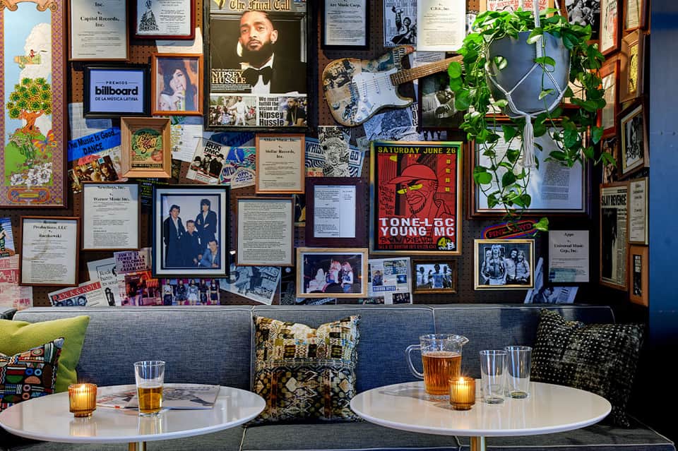 Upscale lounge bar with music memorabilia wall, framed photos, guitar décor, and comfortable seating