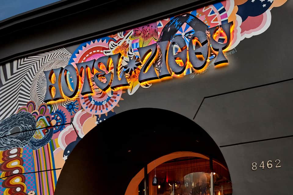 Colorful Oonassis restaurant storefront with vibrant artistic signage and street-level entrance