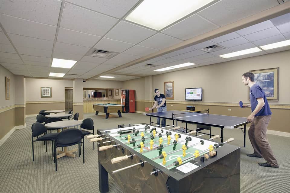 Recreation room with foosball table, pool table, and ping pong table, arcade games visible
